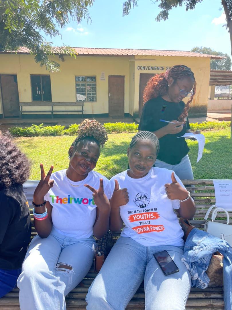 Two young women smiling on a bench at a Youth Na Power community event