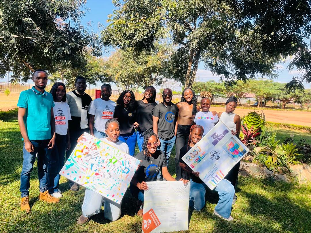 Youth Na Power members gathered outdoors with hand-painted posters after a workshop