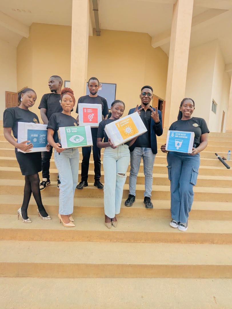 Members holding Sustainable Development Goals boxes on the steps of a hall