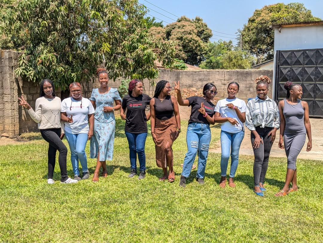Young women of Youth Na Power standing together on the grass after a session